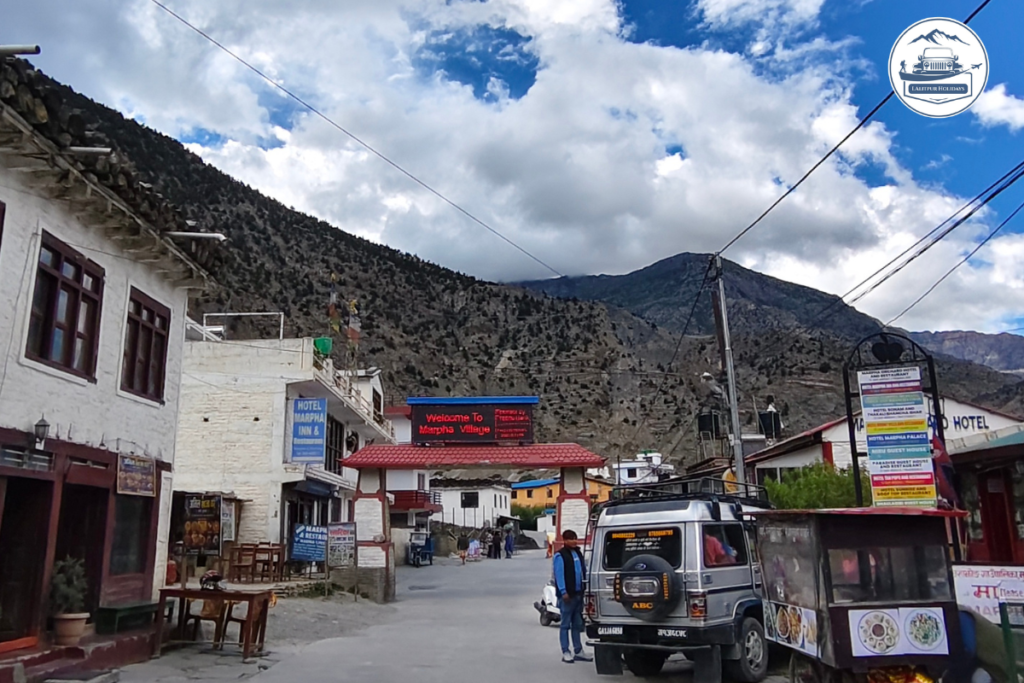 Road through Marpha village in Mustang with local hotels and a Jeep