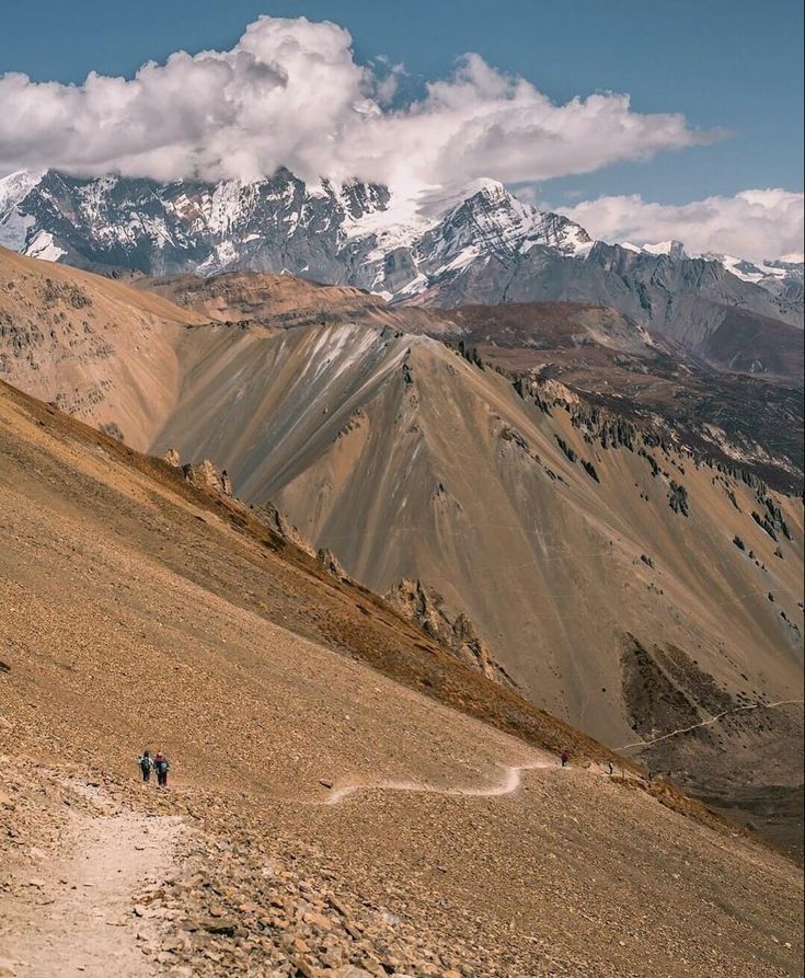 Trekkers crossing the mountain trail toward Tilicho Base Camp